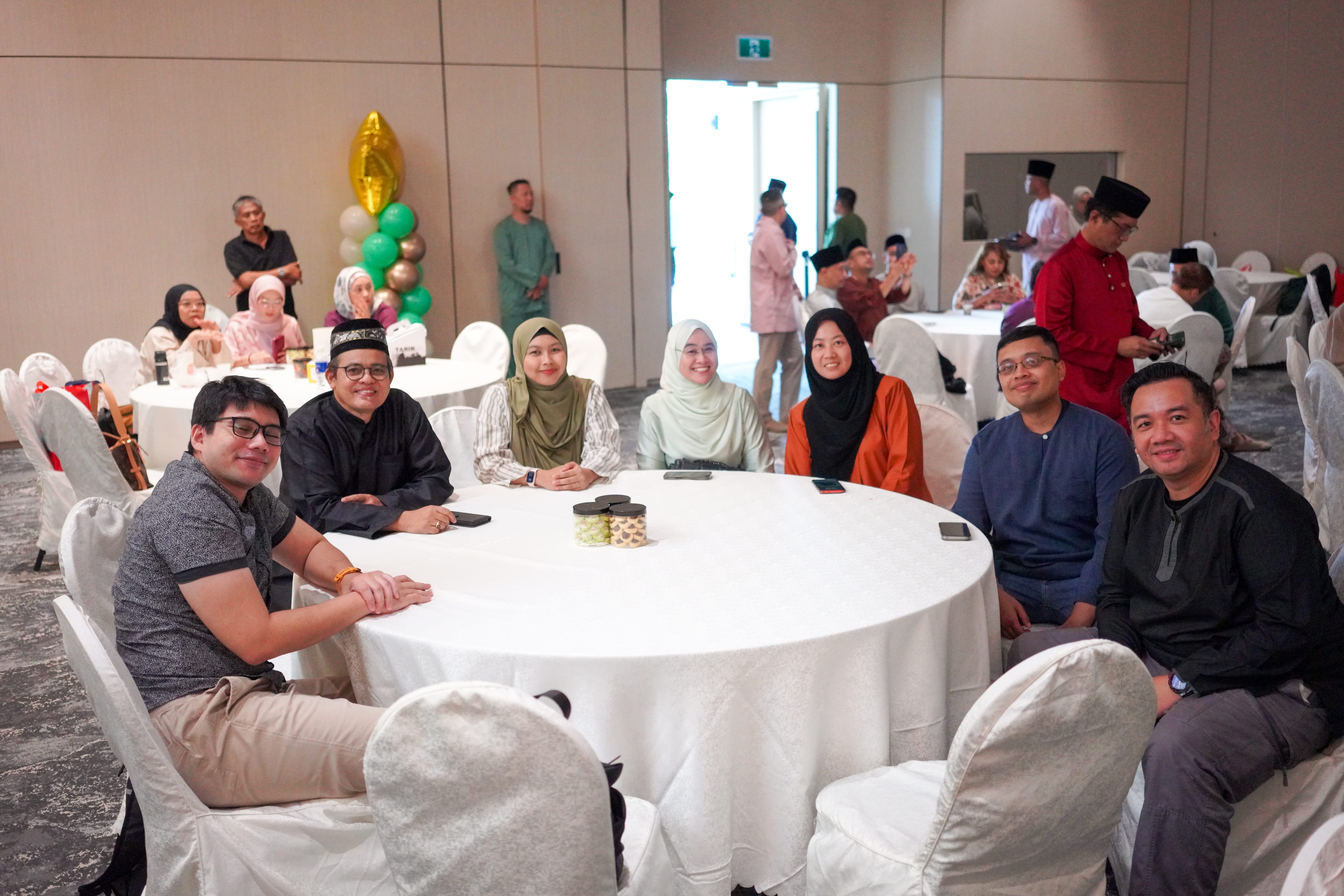 Guests seated at a table in the function hall awaiting commencement of the programme.